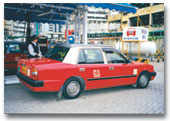 An LPG taxi fills up with LPG at an existing filling station. The LPG fuel tank can be seen in the background 