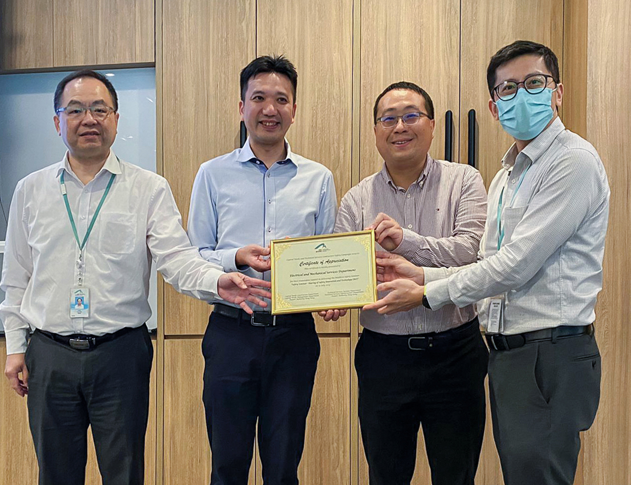 機管局總經理—基本工程管理陳浩榮先生（左一）和高級經理—技術系統杜光卓先生（右一）頒發感謝狀予兩名機電署代表（中）。