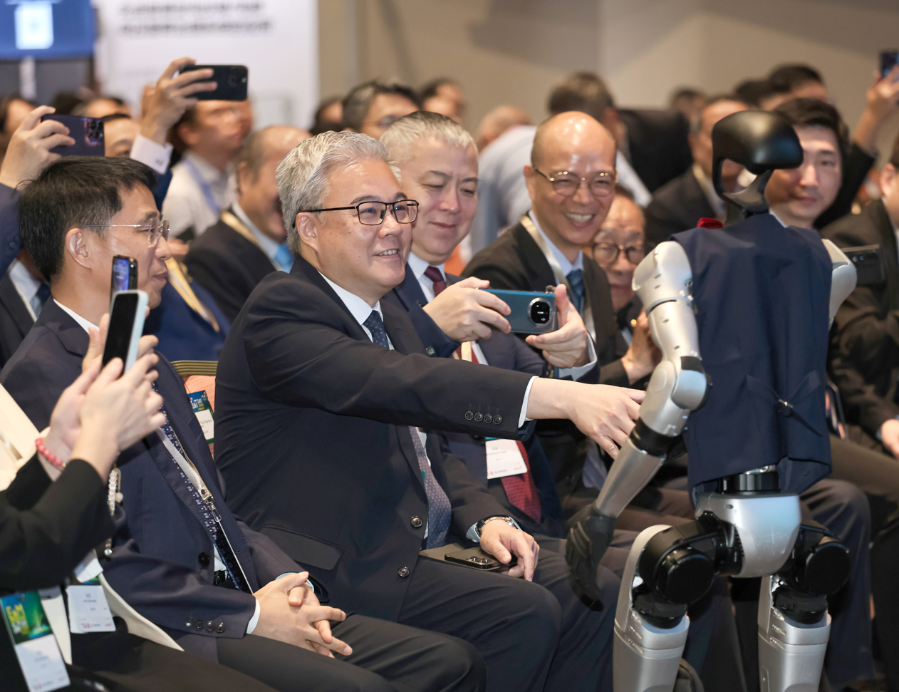 機電署署長潘國英先生在機電創科日上與智能機械人互動，現場氣氛熱烈。活動吸引超過400名來自香港及大灣區其他城市的參加者，共同探討機電創科的前景。